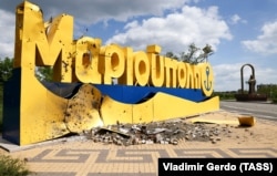Ушкоджена обстрілом стела на в'їзді до міста Маріуполь з боку Бердянська та пам'ятник митрополиту Ігнатію Маріупольському (праворуч), 23 травня 2022 року