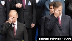 Президент Росії Володимир Путін (ліворуч) і президент України Віктор Янукович хрестяться під час богослужіння, приуроченого до 1025-річчя Хрещення України-Русі. Київ, 27 липня 2013 року